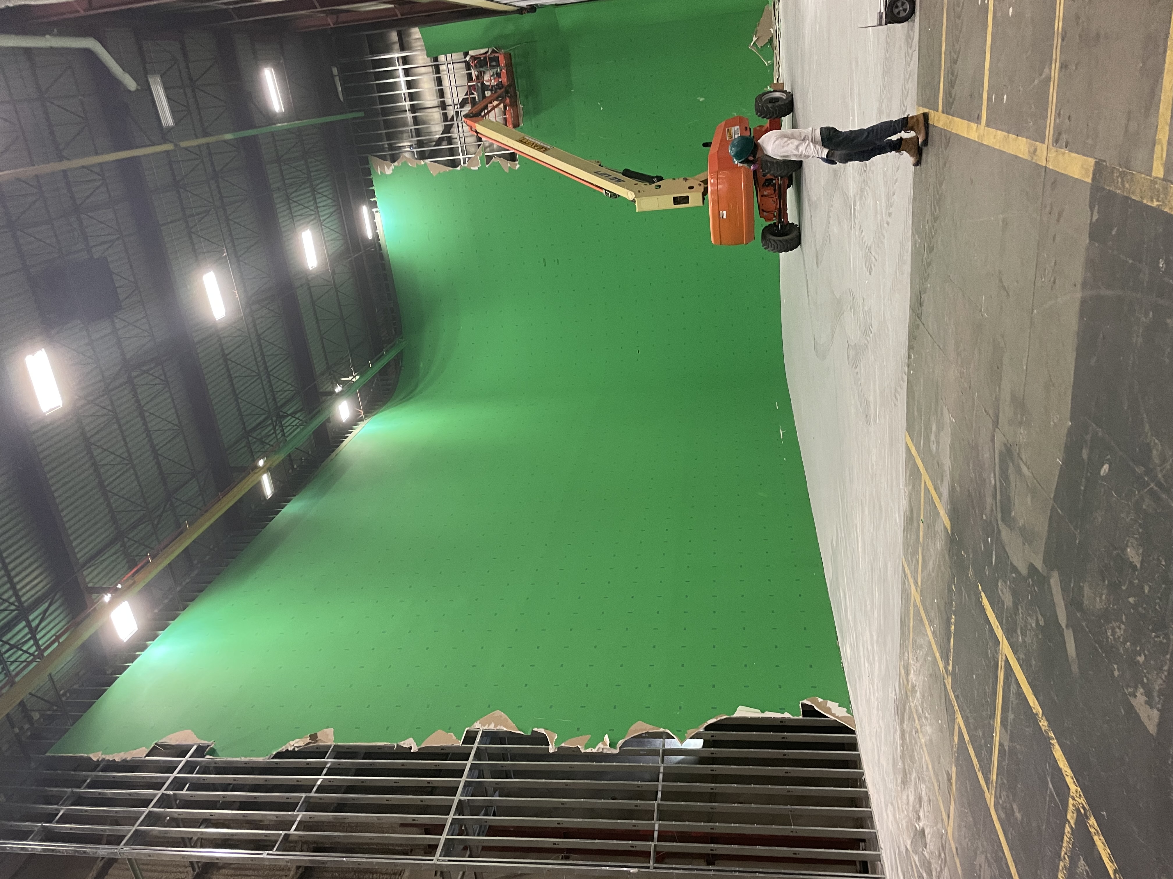 Interior building alterations at Warner Bros. Studios in Langley with large green production wall and lift equipment